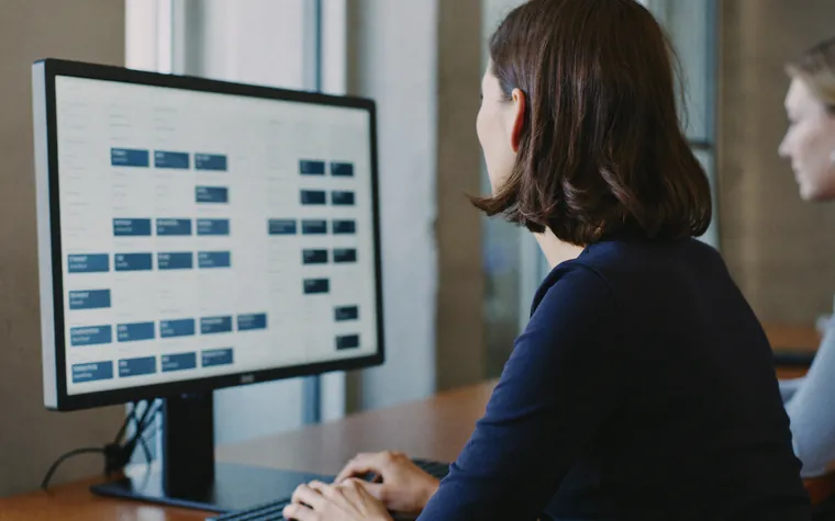 An administrator at a monitor working through a board of user accounts and the access set against each one.