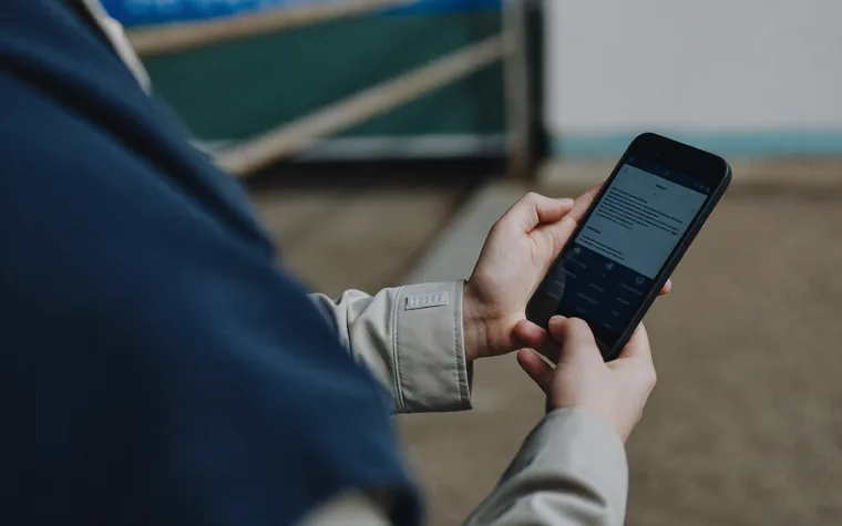A worker checking their training record on a phone while out on site.